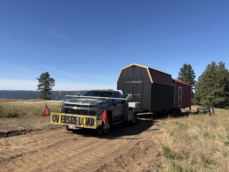 Clearwater Barns truck delivering a shed on a rural road