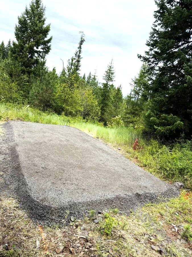 Crew guiding a shed off the truck onto a finished gravel pad
