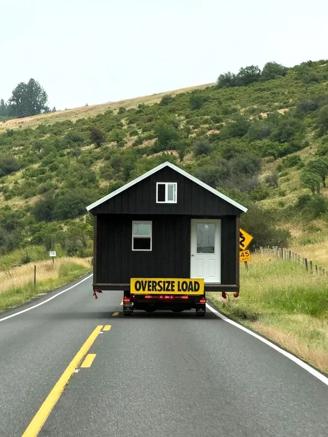 Shed being tilted off the delivery trailer at a rural property