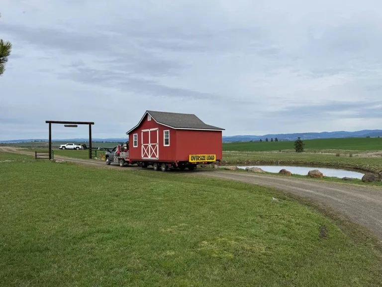 Delivery crew in action placing a storage building