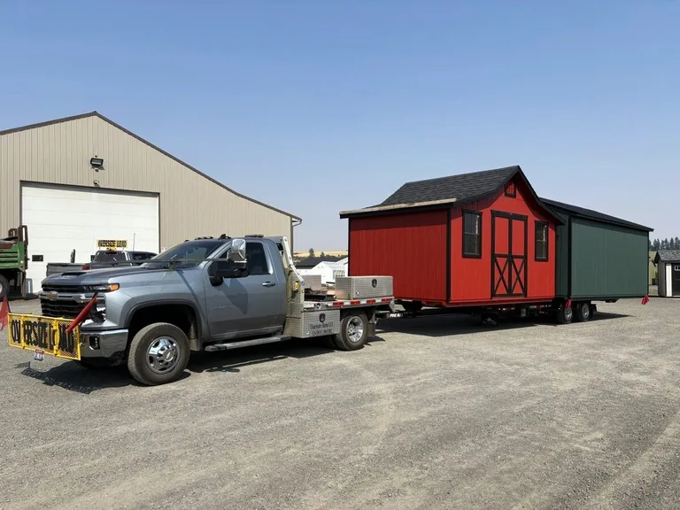 Crew placing a shed on blocks over a compacted base