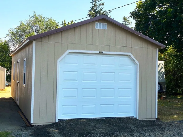 Tan garage with oversized white overhead door and gable vent