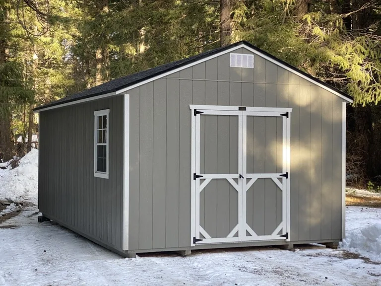 Gray utility storage shed with white double doors and a side window