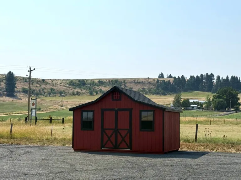 Red Rancher barn with black trim doors overlooking rolling Idaho hills