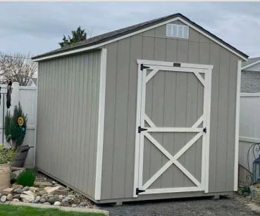 Gray utility style shed with single door in a backyard