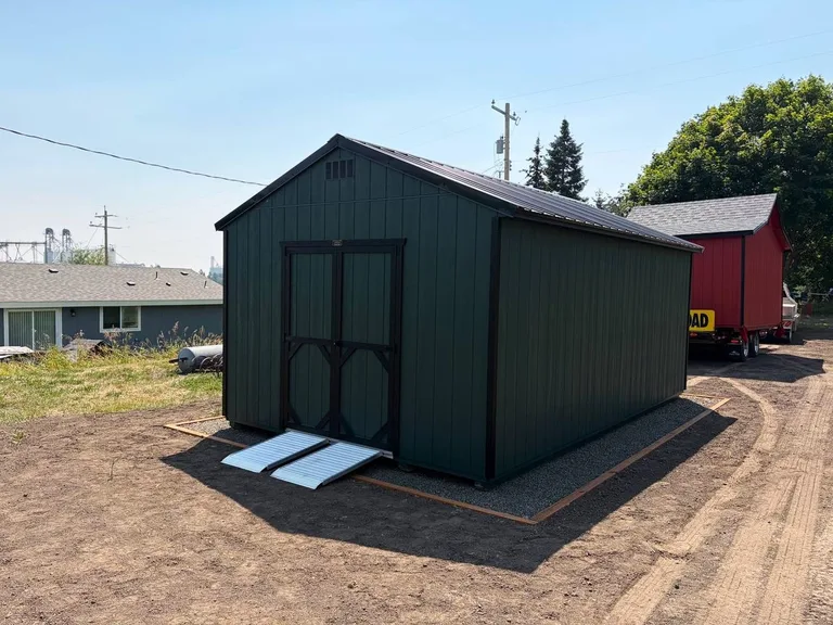 Dark green utility style shed with loading ramps